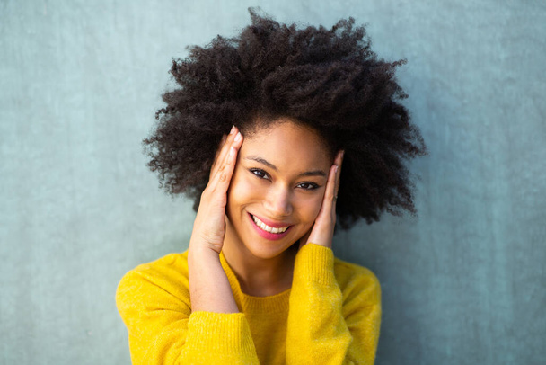 Close up horizontal portrait happy young black woman smiling with hands on face  - 写真・画像