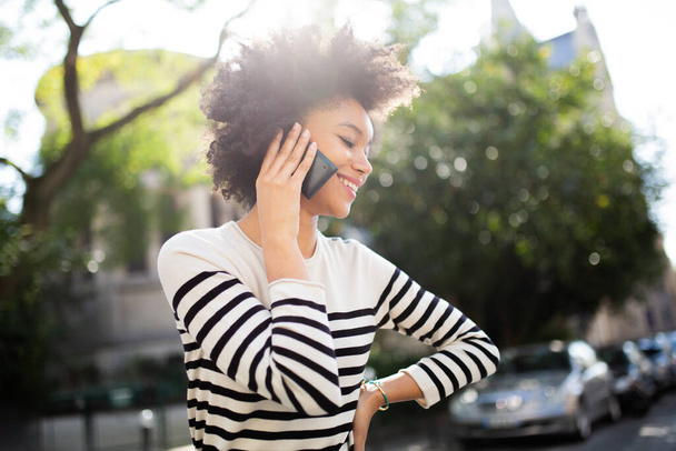 Portrait happy young african american woman talking with phone outside - Fotoğraf, Görsel
