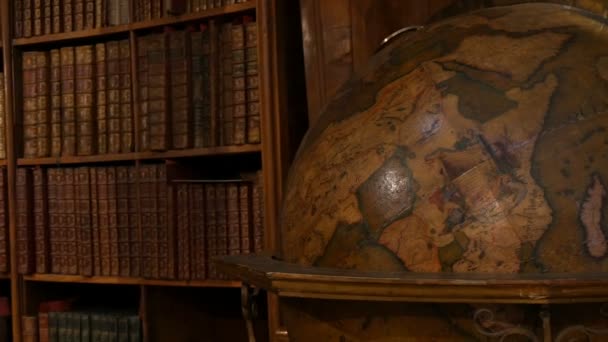 Old large vintage antique globe. Beautiful vintage old bookshelves with nameless books. Interior of the Austrian National Library with a number of old vintage books on the shelves. - Footage, Video