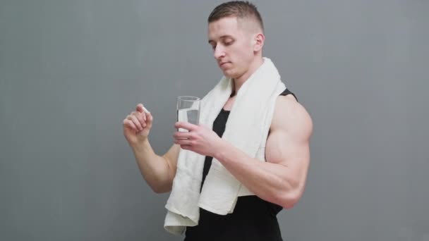 Mann hält Pillen als Nahrungsergänzung zur Sporternährung in der Hand - Filmmaterial, Video