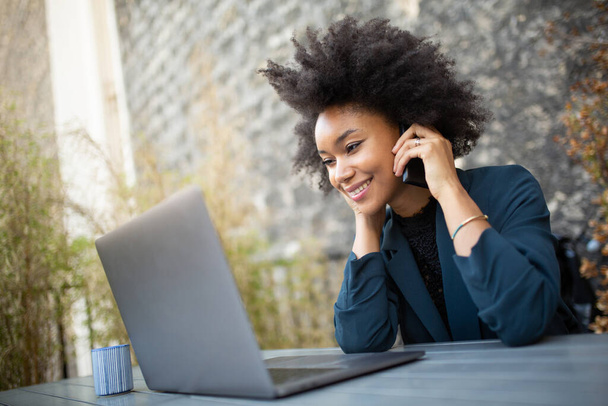 Gros plan portrait souriant femme d'affaires travaillant avec ordinateur portable et téléphone portable
 - Photo, image