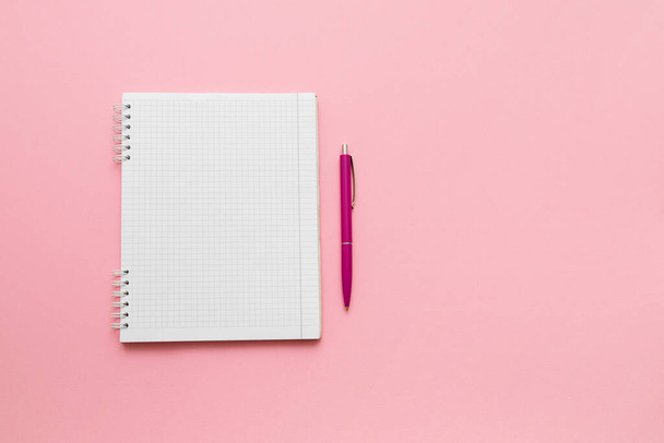 Women's notes. Blank sheet notepad and pen for notes on a pink background. Top view. - 写真・画像
