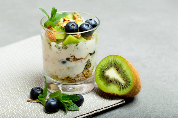 Parfait de granola con yogur, frutas y bayas en vaso de cerca, desayuno saludable
 - Foto, Imagen