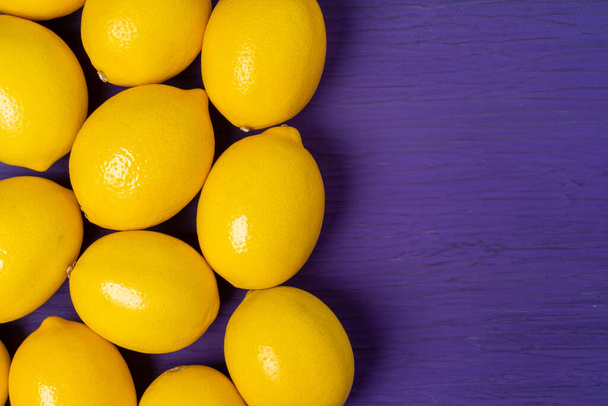 Top view of lemon on purple wooden background - Фото, зображення