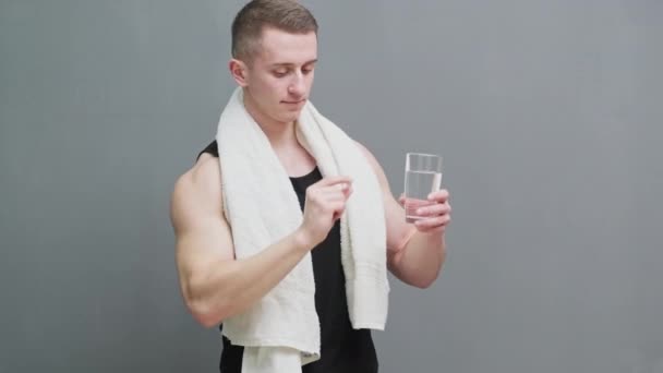 Mann hält Pillen als Nahrungsergänzung zur Sporternährung in der Hand - Filmmaterial, Video