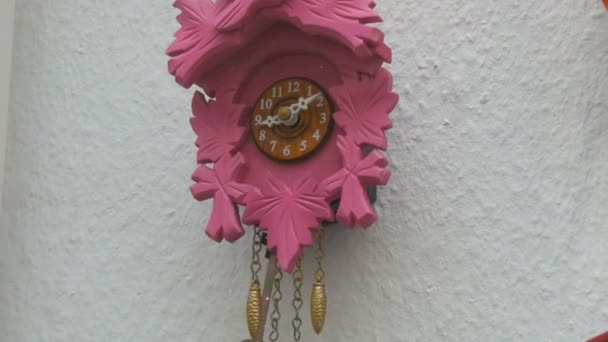 Zegar ścienny różowy z wahadłem w oknie sklepu z zegarkami - Materiał filmowy, wideo