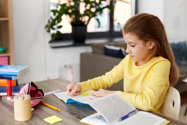 étudiante fille avec écriture de livre pour ordinateur portable à la maison - Photo, image