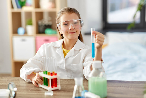 girl with test tube studying chemistry at home - Foto, Imagem