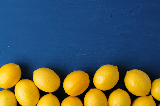 Lemon on classic blue background, top view - Foto, afbeelding
