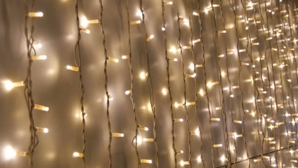 Duvarda, parlak, güzel, beyaz, elektrikli bir çelenk. Noel dekoru. Noel tatili için soyut arkaplan LED ışıkları - Video, Çekim