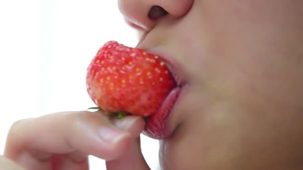 Asian pretty woman holding and eating fresh strawberry is red berry fruit color and sweet juicy with enjoy and happy emotion in concept food, healthy eating in life (Slow motion) - Footage, Video