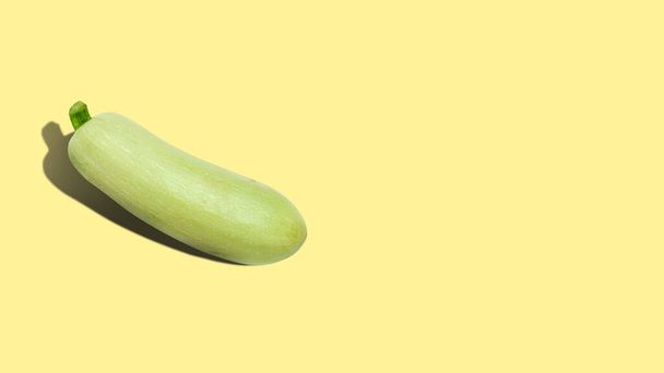 Ripe zucchini on a yellow background with copy space. Close up. - Foto, imagen