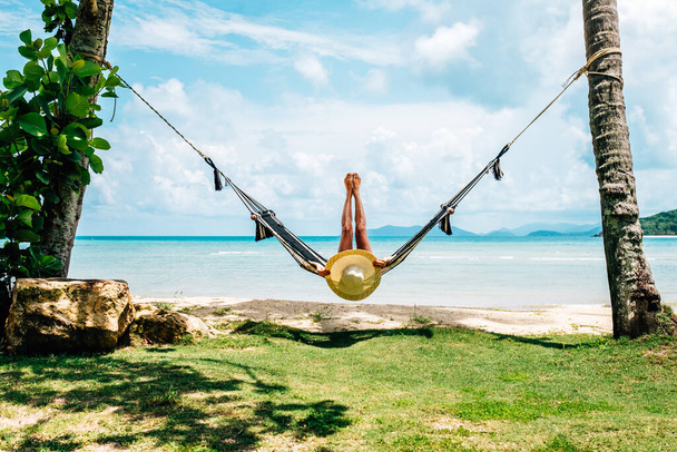 Summer vacations concept. Happy woman in black bikini relaxing in hammock on tropical beach - Fotografie, Obrázek
