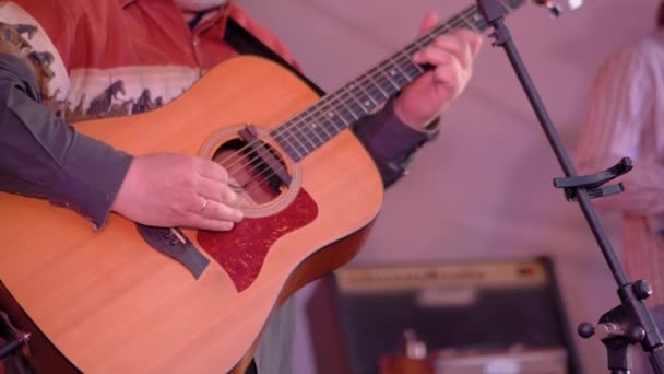 Повільний рух: рука людини грає на акустичній гітарі на сцені концерту під відкритим небом
 - Кадри, відео