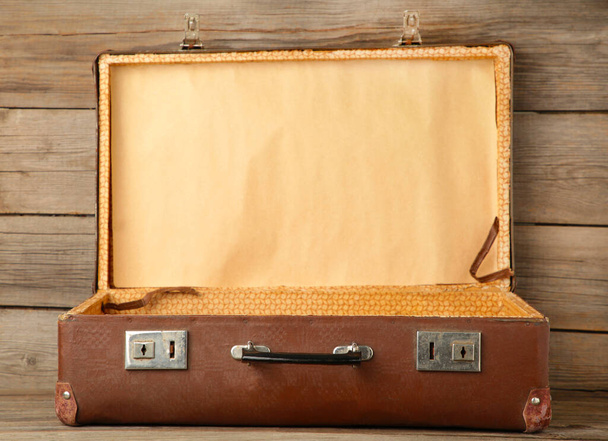 Open old shabby leather portable suitcase for travel trip on grey wooden background. Top view - Fotoğraf, Görsel
