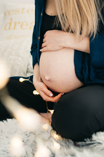 Беременная девушка держит руки на животе
  - Фото, изображение
