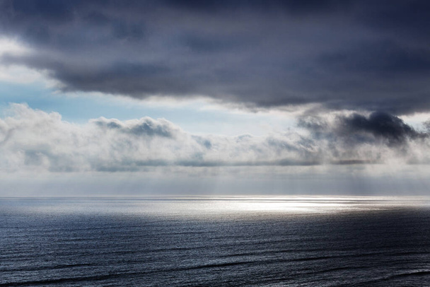 rays of sun through the clouds over the ocean - Fotoğraf, Görsel