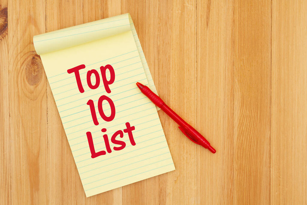 Top 10 mensaje de la lista en un papel de bloc de notas legal amarillo y pluma en escritorio de madera
 - Foto, imagen