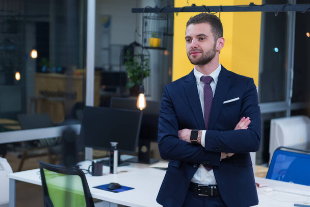 Portrait of young bearded Caucasian businessman dressed smart casual posing inside modern coworking space. - Фото, зображення