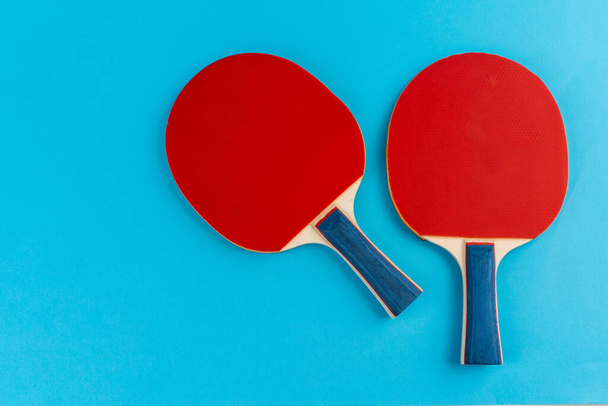 Red ping pong racket on a blue background - Foto, afbeelding