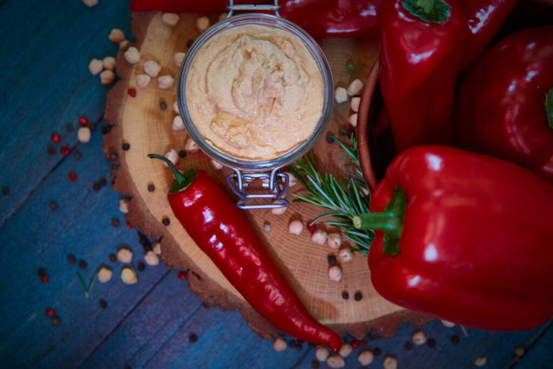 Hummus caseiro com pimenta vermelha em uma mesa de madeira. Foco seletivo e pequena profundidade de campo
 - Foto, Imagem