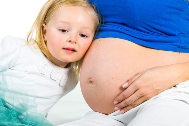 Pregnant woman with 2 yo daughter on white - Fotografie, Obrázek