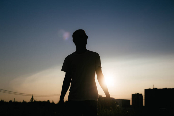 sylwetka mężczyzny na tle letniego zachodu słońca w mieście - Zdjęcie, obraz