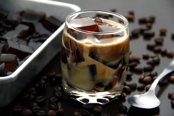 Фото кави зі смаком желе з молоком в прозорому склянці на столі
. - Фото, зображення