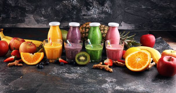 Assortment of fruit smoothies in glass bottles. Fresh organic Smoothie ingredients. Smoothies for health or detox diet food concept. - Фото, зображення