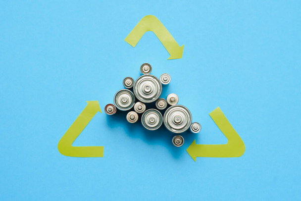 Used batteries with recycling sign top view. Symbol of caring for the environment. Danger of contamination by decomposition products of batteries. - Zdjęcie, obraz
