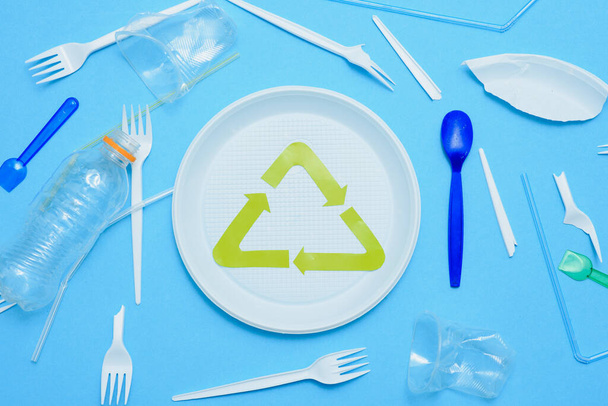 Different plastic trash and garbage recycling sign on a colored background top view. The concept of saving the planet, the separation of garbage. - 写真・画像