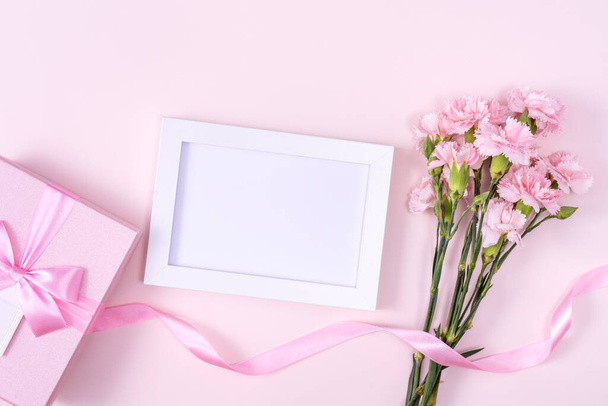 Den matek, Valentýn pozadí design koncept, krásný růžový karafiát kytice na pastelově růžový stůl, horní pohled, byt ležel, kopírovací prostor. - Fotografie, Obrázek