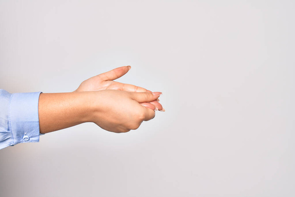 Молодая белая женщина очищает руки с помощью спиртовой жидкости на изолированном белом фоне - Фото, изображение