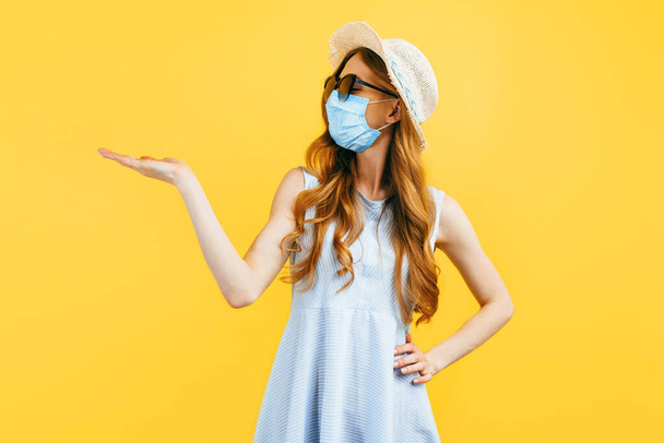 Portrait of a girl in a hat in summer, wears a medical protective mask against a viral infection, on a yellow isolated background. Quarantine, coronavirus, summer - Fotoğraf, Görsel