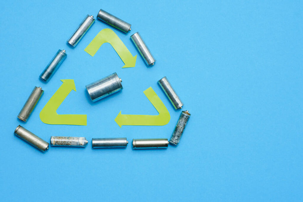Scattered old dirty batteries aa or aaa size on blue background. Recycling concept. Save environment. Alternative energy - Photo, Image