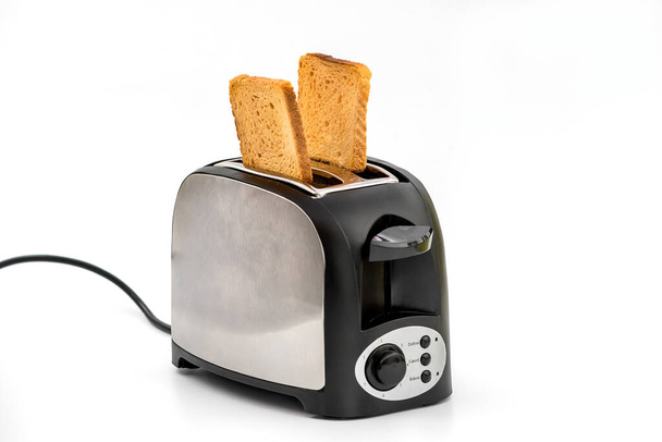 Toasts jumping out of retro style black and metallic toaster on white background. Levitation food. Kitchen equipment for fresh morning meal - Photo, Image