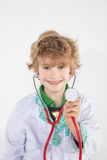 young doctor with stethoscope stands on a white background - Фото, изображение