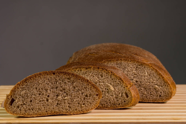 Zwart brood met sesamzaad. Op een houten plank - Foto, afbeelding