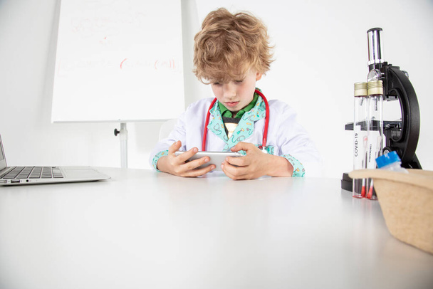 young doctor uses the phone, sitting in his office - Photo, image