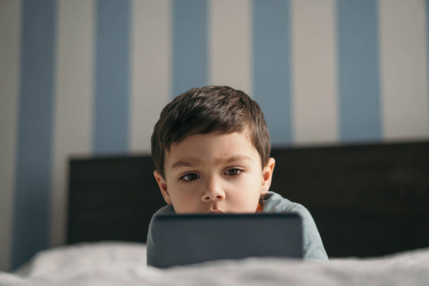 valikoiva painopiste suloinen poika tarkastellaan älypuhelin makuuhuoneessa
 - Valokuva, kuva