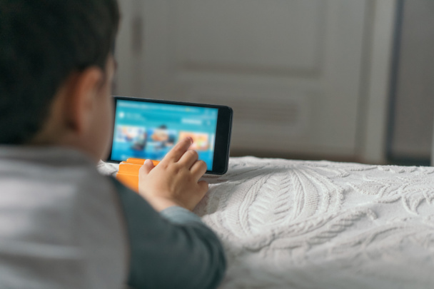 foyer sélectif de garçon touchant l'écran du smartphone tout en regardant leçon en ligne
 - Photo, image