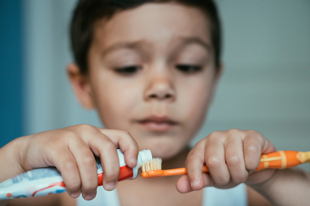 szelektív fókusz szorgalmas fiú alkalmazó fogkrém fogkefe - Fotó, kép