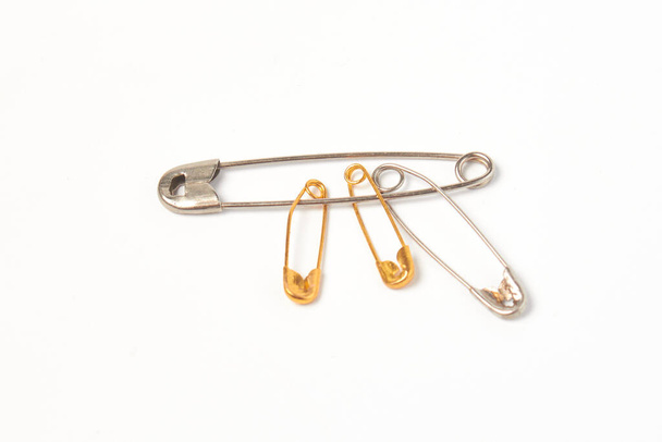 different pins of steel and gold color on a white background isolate - Fotó, kép