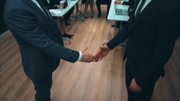 De zakenmensen schudden elkaar de hand in de vergaderzaal. slow motion - Video