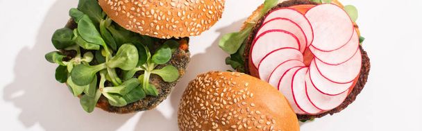vista superior de hambúrgueres vegan com microgreens, rabanete sobre fundo branco, tiro panorâmico
 - Foto, Imagem