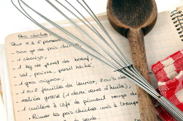Libro de recetas con cuchara de madera y batidor de cocina de cerca
  - Foto, imagen