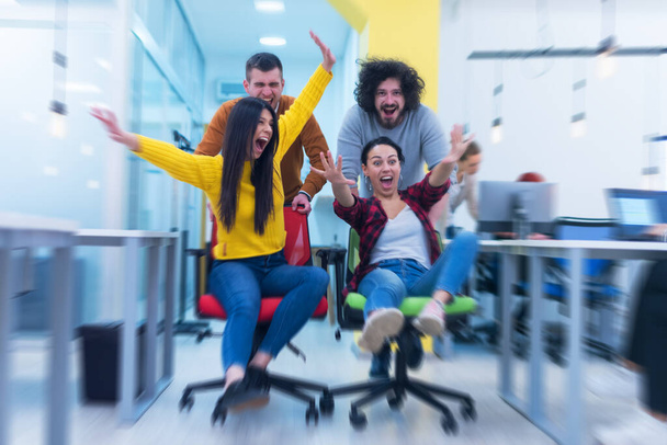 Grupo de trabajadores de oficina creativos colaboran juntos haciendo bromas entre sí durante su trabajo dentro de la oficina. éxito y competencia concepto de negocio - Foto, Imagen