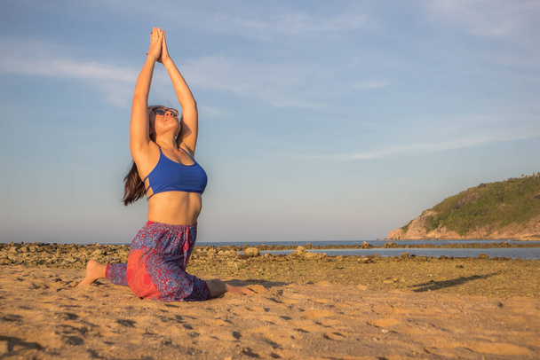 Tayland 'ın Koh Phangan adasındaki Mae Haad plajında yoga yapan Asyalı kadın. Güvercin poz yoga - Fotoğraf, Görsel