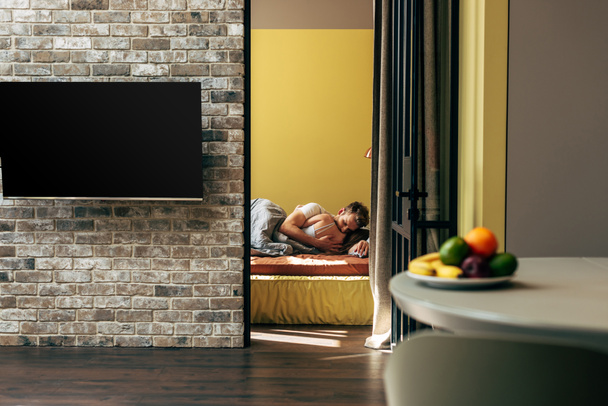 вибірковий фокус порожнього екрану телевізора біля пари в ліжку
  - Фото, зображення