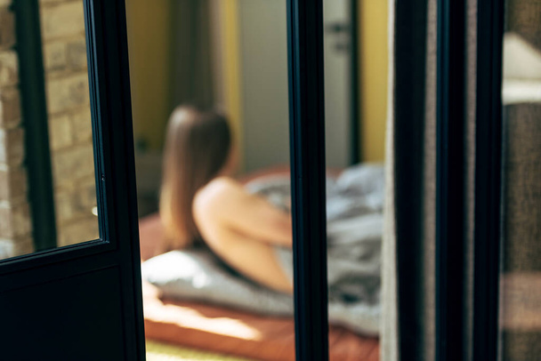 selective focus of door near sensual woman lying in bedroom  - Fotoğraf, Görsel